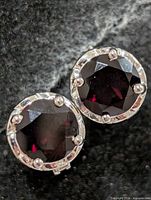Front view showing round faceted garnet stones in silver bezels