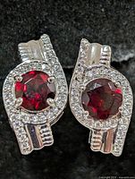 Front view of both earrings showing garnet centers and CZ halos