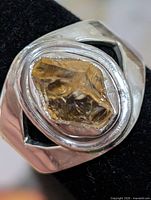 Front view of silver ring showing rough yellow gemstone in bezel setting