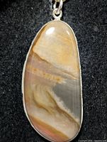 Front view of oval jasper pendant showing stone pattern and silver bezel