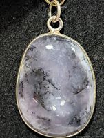 Front view of oval dendritic agate pendant in silver bezel