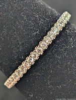Side view of thin silver band fully set with small round cubic zirconia stones