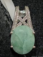 Front view of silver pendant with oval dyed emerald