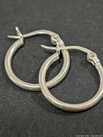 pair of silver hoop earrings lying flat to show overall design