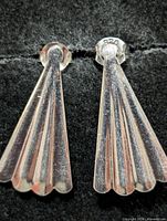 Front view of both sterling silver fan-shaped earrings showing polished finish and scalloped lower edge