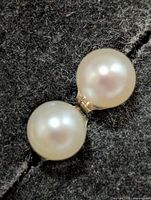 front view of both pearl studs against dark backdrop