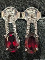 Front view of both earrings showing garnet stones, accent stones and 925 stamp