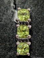 Front view of pendant showing three peridot stones and spinel accents