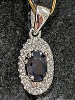 Front view of pendant showing sapphire and CZ halo