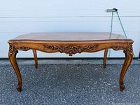 full view of carved mahogany coffee table front and side
