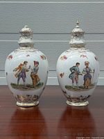 Front view of both porcelain urns showing courtship scenes and overall form