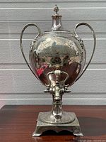 Front view showing complete urn with lid, handles, base