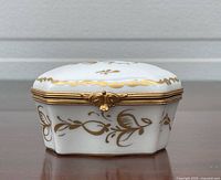 Closed trinket box showing front, lid decoration and clasp