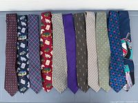 All eleven ties laid flat side by side showing full patterns and colours