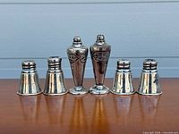 Front view of all six sterling silver shakers showing two styles
