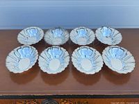 All eight scalloped sterling nut dishes top view