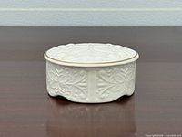Side view of closed porcelain trinket box showing embossed pattern