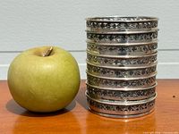 Stack of coasters beside apple showing rim detail and scale