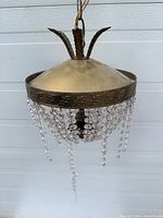 Full view of chandelier showing metal canopy, crystal strands, missing prisms