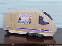 Left side exterior view of Barbie motorhome showing window graphic and stripe