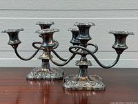 Front view of both silver-plated triple candelabras