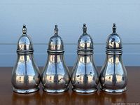 Front view of all four sterling silver shakers