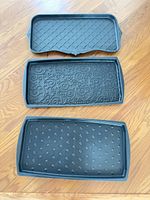 Three black rubber trays laid out showing patterns