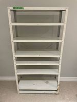 Full front view of white metal shelving unit showing seven shelves