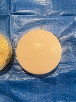 Opal glass shade and pressed amber patterned glass shade on tarp