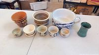 Group shot of all ceramic and pottery items lined up on table