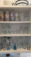 Cabinet view showing full assortment of barware across three shelves