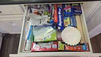 Drawer overview showing foil rolls, bag boxes, liners, tea lights, baking cups