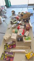 Overall view of table with mixed boxed bulbs, tubes, timers and sockets