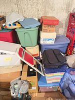 stacked plastic totes, cardboard boxes and assorted items
