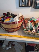 two baskets filled with assorted scarves displayed on table