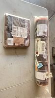 Sealed runner roll and packaged rug pad on table