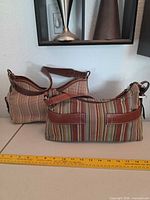 Both Fossil shoulder bags side by side showing size, stripe patterns, leather trim and straps