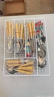 Full set in white drawer organiser showing bamboo-style and polka-dot handled pieces