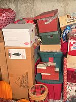 Stacked boxes and totes containing holiday items with visible plaid picnic basket