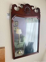 Front view of mahogany Chippendale wall mirror hanging on wall