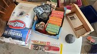 Full lot overview showing charcoal bag, wood chip boxes, pellets pouch, lighter, additional small item