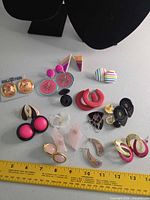 All earrings laid out beside ruler for scale