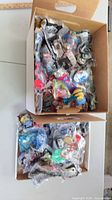 Two boxes filled with sealed Happy Meal toys