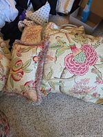 Group of floral pillows showing pattern, fringe and inserts