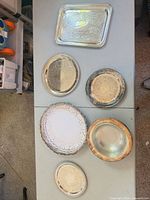 All seven silverplate pieces laid out on table