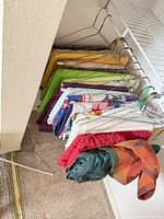 Tablecloths and runners hanging on hangers showing variety of colors and patterns