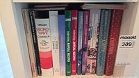 Single shelf of approx. 14 cookbooks and annual recipe volumes with readable spines