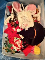 Overhead view of plastic bin containing mixed headbands and hats