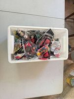 White bin containing numerous individually bagged Happy Meal toys