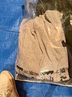 Bagged lot showing gray towel with patterned trim beside dark fabric